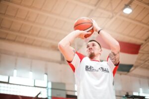 Focused man playing basketball in basket hall