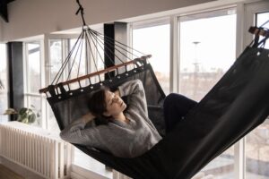 Tired woman sleeping in cozy hammock in flat