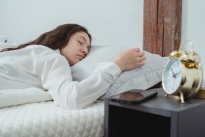 Young female sleeping on bed in morning