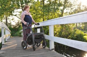 elderly woman walking with a rollator walker